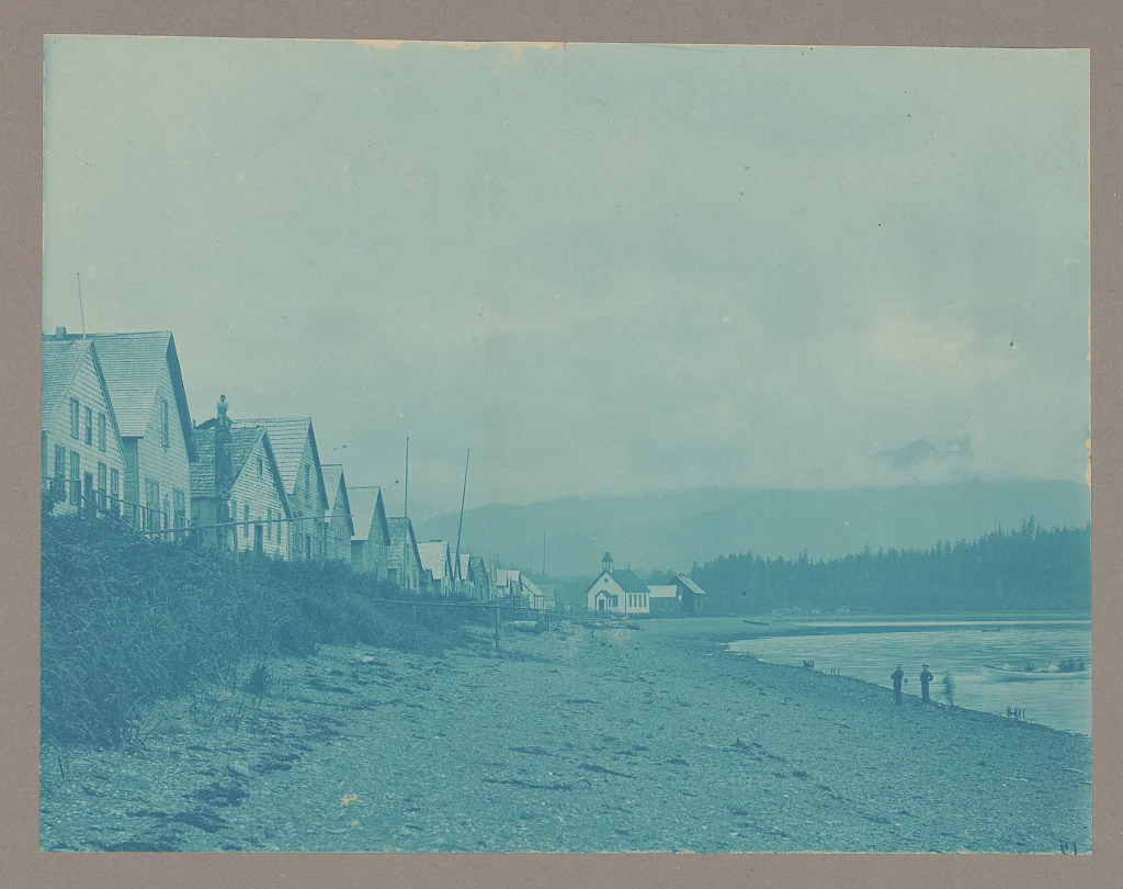 1884 photograph of the Hoonah, Alaska waterfront with wooden clan houses along a gravel beach