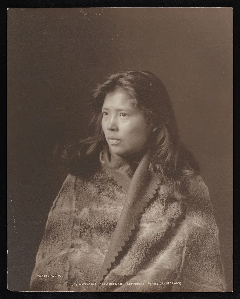 1907 sepia studio portrait of a Huna Tlingit woman named Tootch-Wu-Wu Lucy wrapped in a fur robe