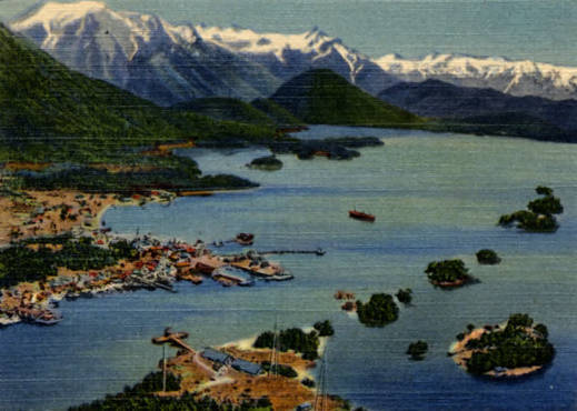 Cruise ship sailing through the forested Inside Passage with snow-capped mountains