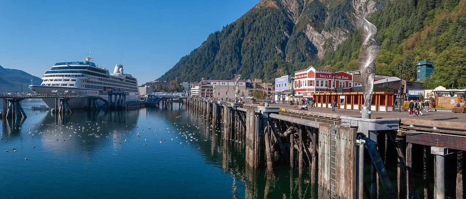 Cruise ship docked at Juneau waterfront with mountain backdrop