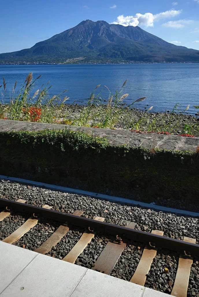 Buried torii gate on Sakurajima with only the top crossbar visible above hardened lava rock