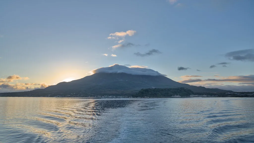 Sakurajima volcano rising from Kagoshima Bay with the city skyline along the waterfront