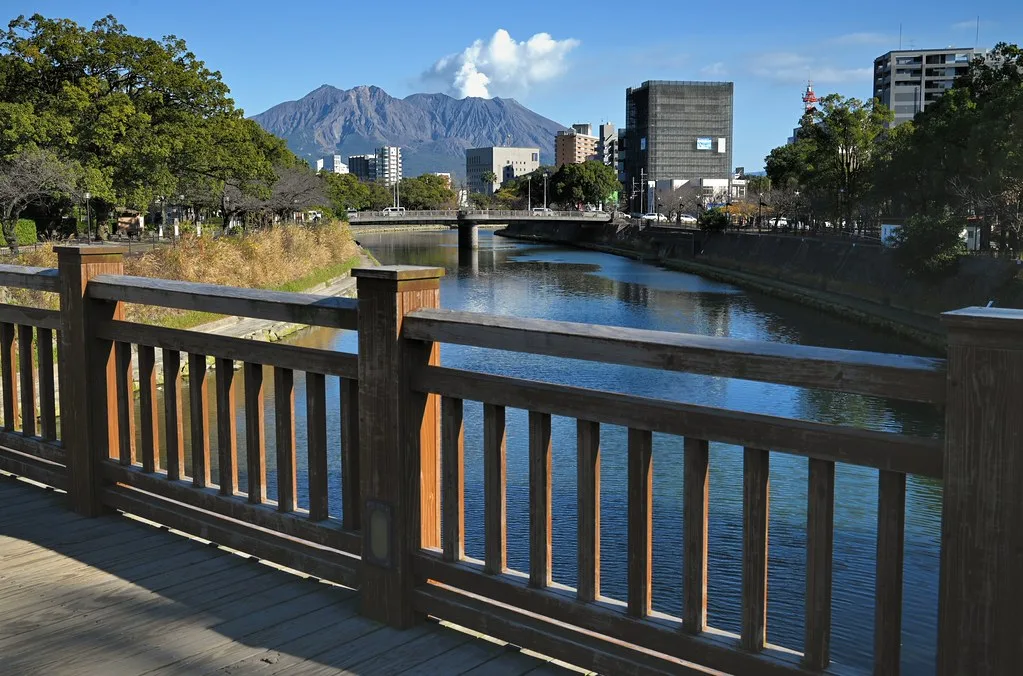 Panoramic view of Kagoshima city at sunset with Sakurajima smoking in the golden light