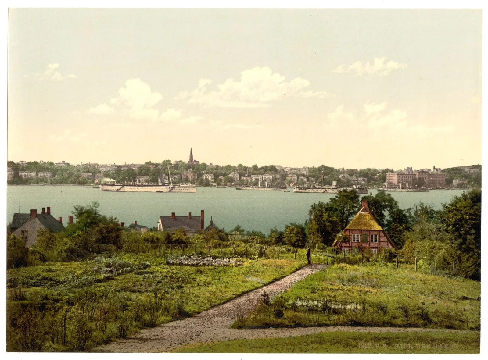 Historical photochrom of Kiel harbor with ships, church spire, and half-timbered house, c. 1900
