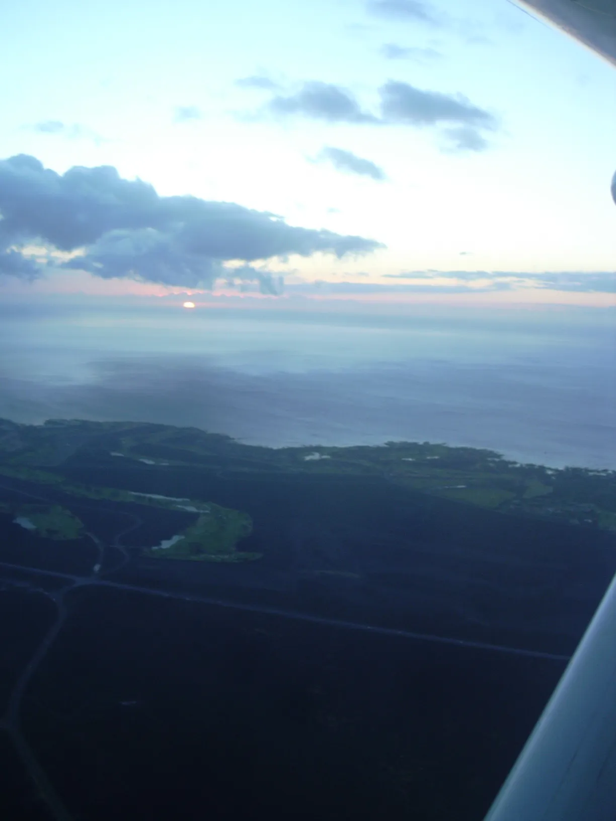 Historic Ali'i Drive streetscape in Kailua-Kona with shops, restaurants, and palm trees lining the road