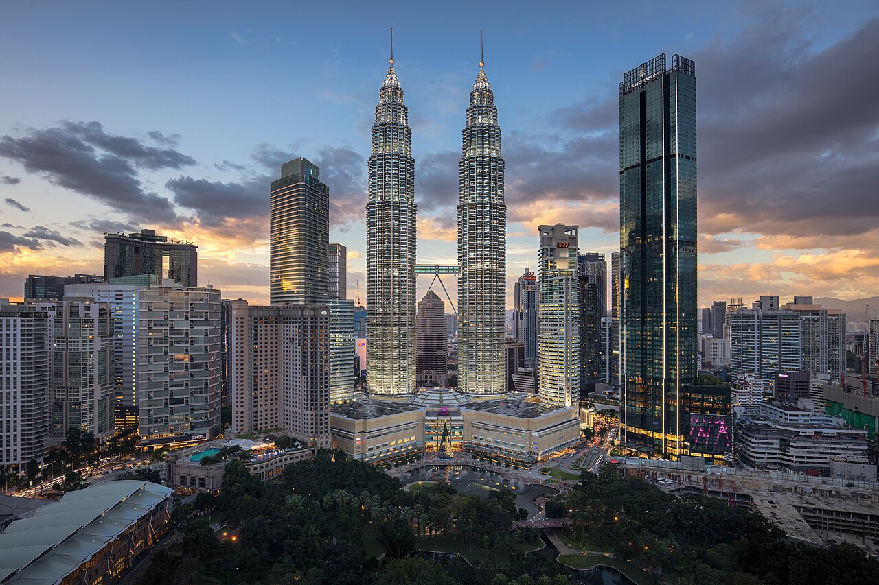Petronas Twin Towers and KLCC skyline at sunset with surrounding skyscrapers