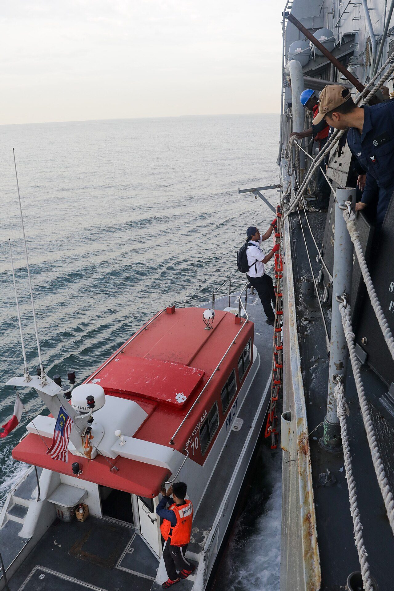 Port Klang container terminal with cargo cranes and a cruise ship docked at the commercial berth