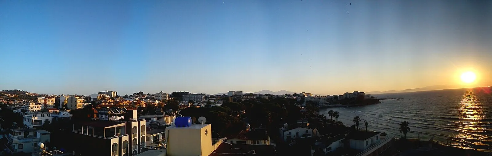 Sunset over Kusadasi harbor with boats in the foreground