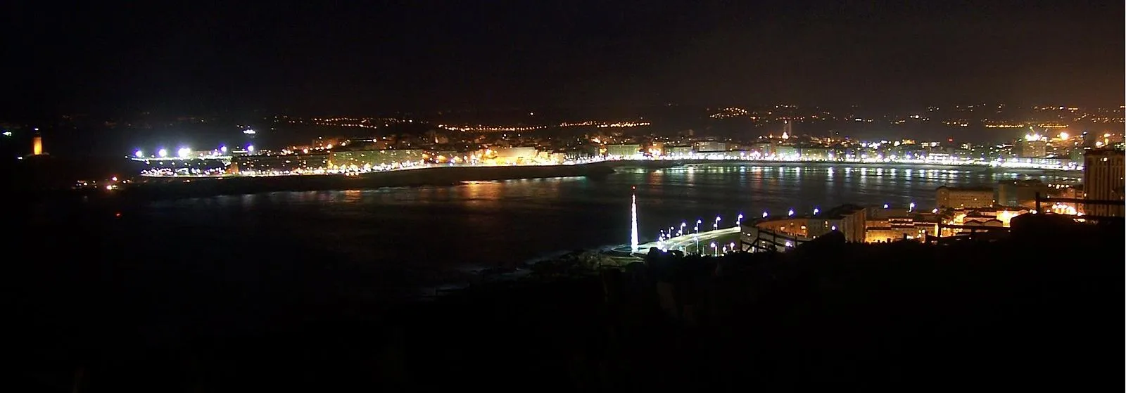 Night panorama of A Coruña bay with city lights reflected on the water