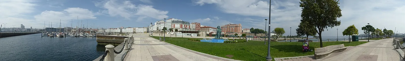 Panoramic view of A Coruña marina with sailboats, galerías buildings, and waterfront promenade