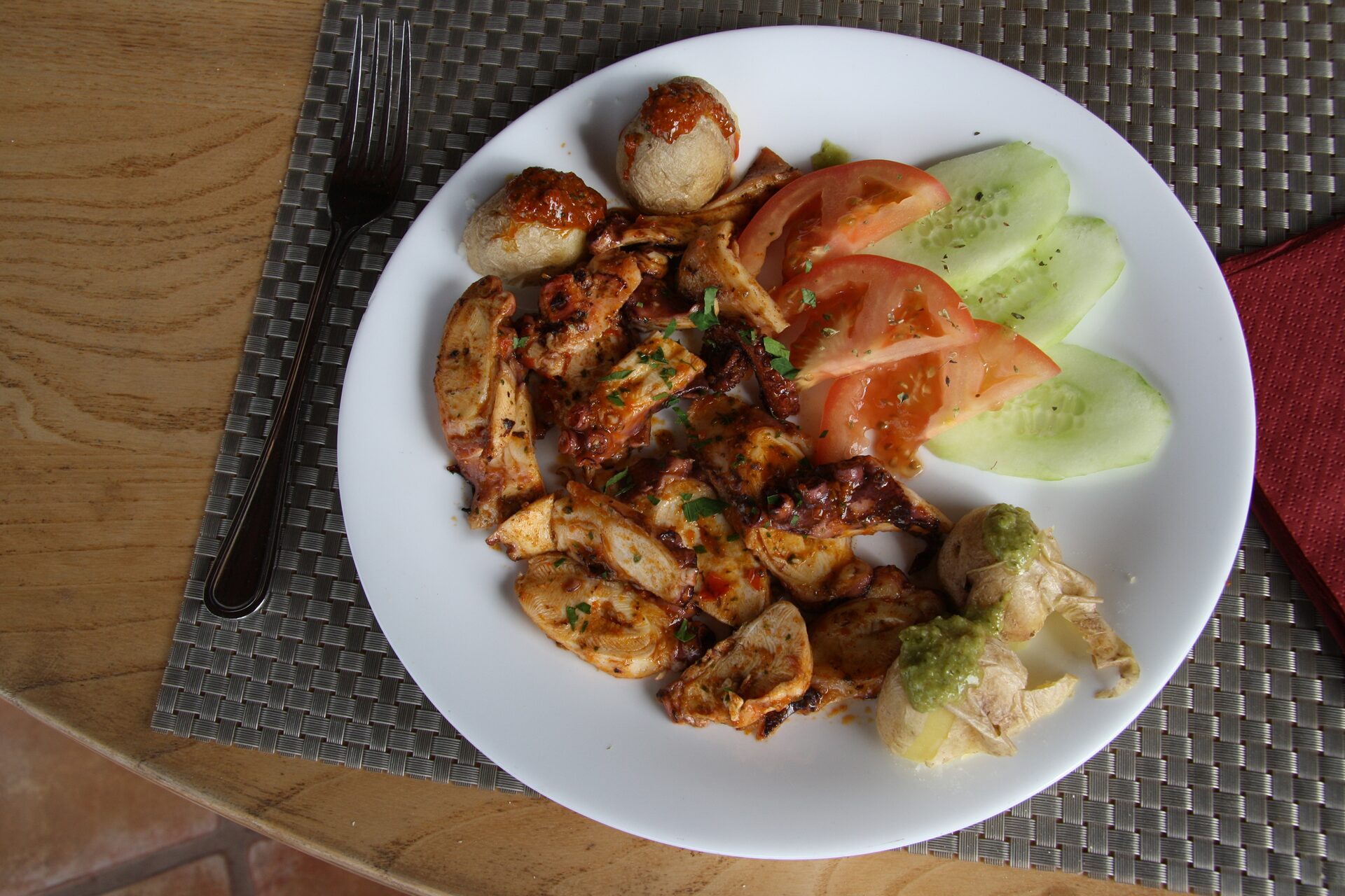 Geothermal demonstration at Timanfaya showing geyser of steam erupting from volcanic ground while visitors watch from safe distance