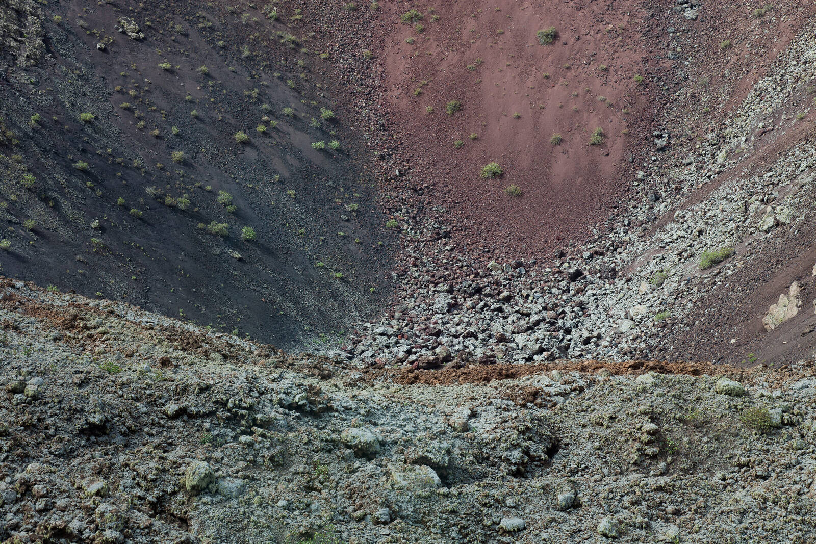 Fire Mountains of Timanfaya showing dramatic red and black volcanic cones with winding road through barren lava landscape