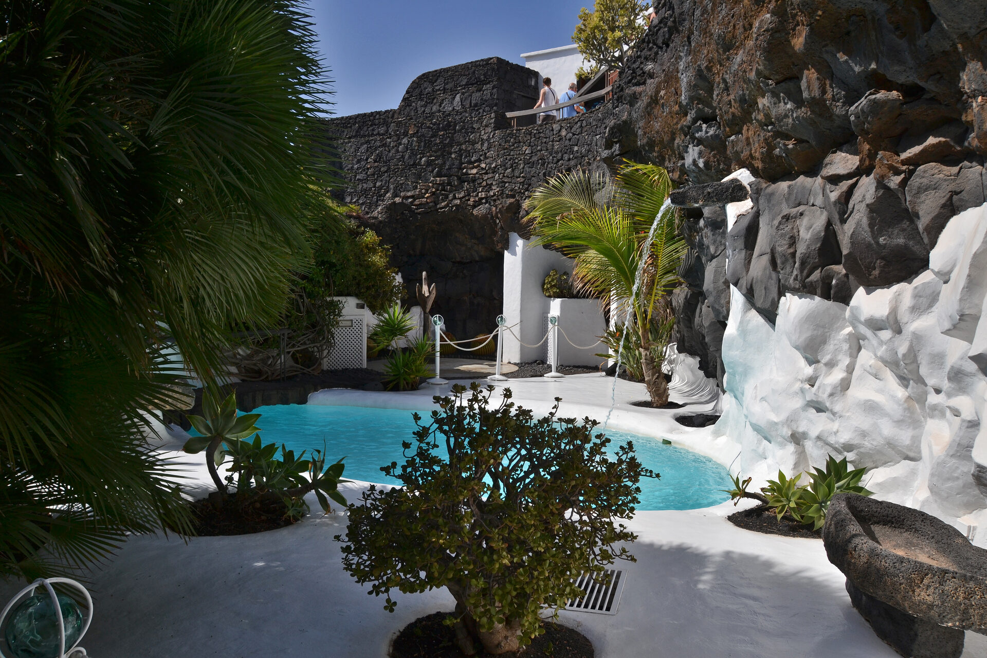 Turquoise pool surrounded by white walls and black volcanic rock at Fundación César Manrique, Lanzarote