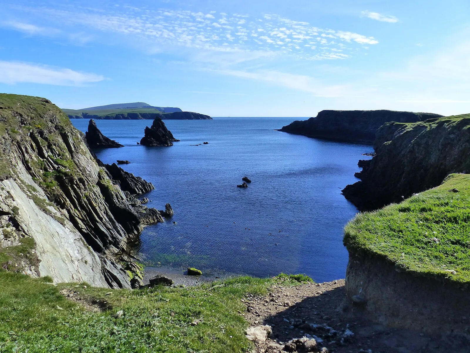 Dramatic Shetland coastal inlet with sea stacks and deep blue water