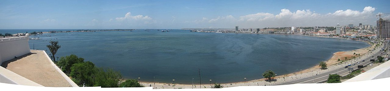 Luanda waterfront skyline at dawn with Fortaleza de São Miguel and modern towers along the Marginal