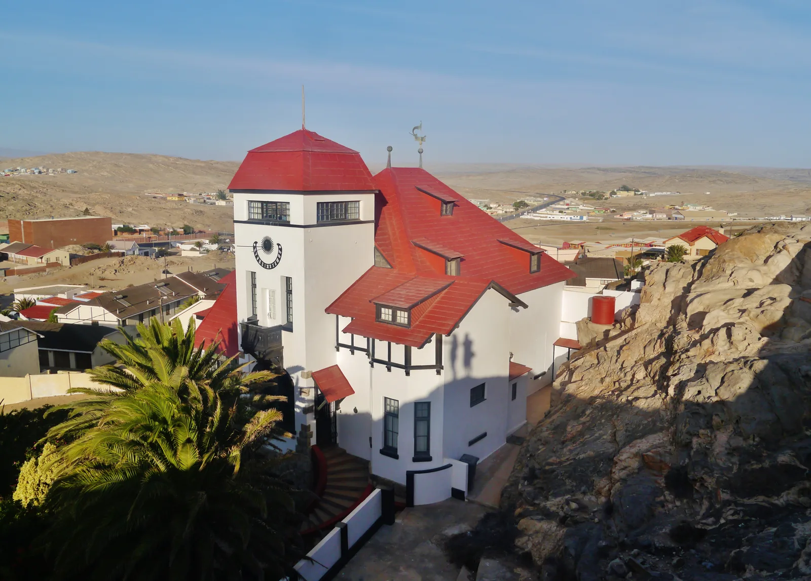 Goerke Haus standing above the town of Lüderitz, its pale walls and steep roof against the rock