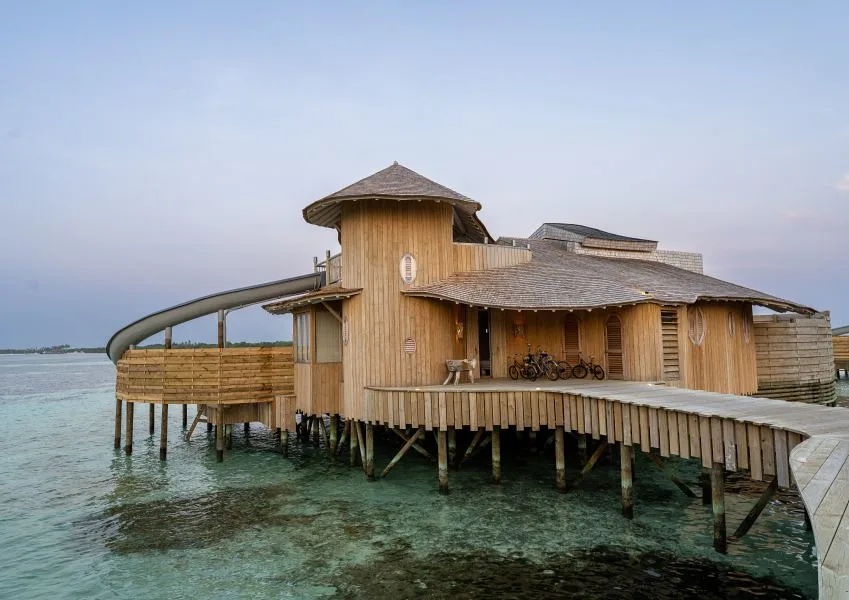 Pristine white sand beach with palm trees and turquoise lagoon on a Maldivian island