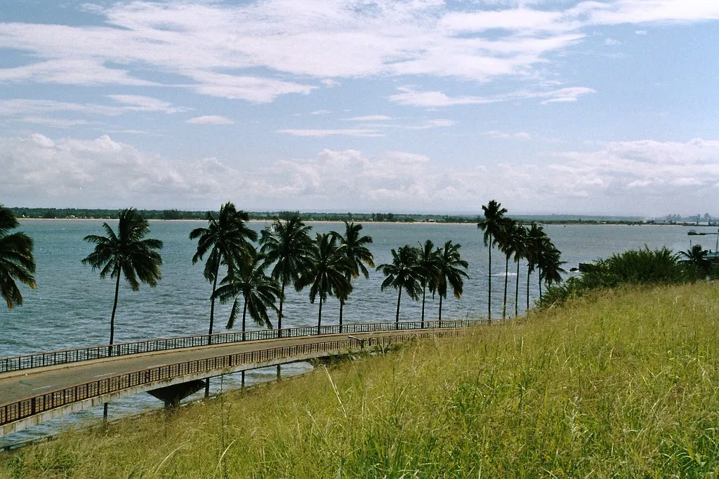 The palm-lined Marginal Promenade along Maputo's waterfront with ocean views and pedestrians walking
