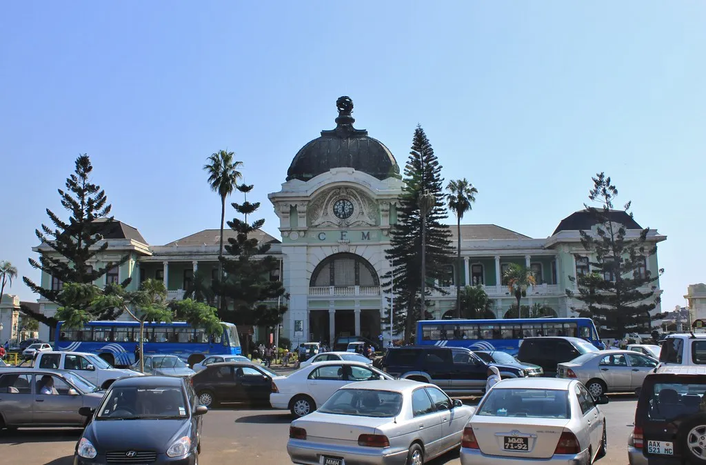 The ornate copper dome and wrought-iron facade of Maputo's CFM Railway Station bathed in morning light