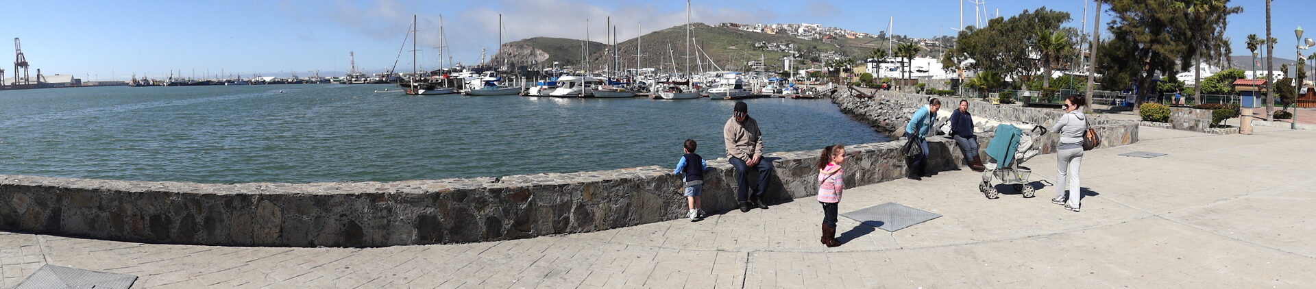 Cliff diver in mid-air launching from rocky outcrop at El Mirador with Pacific waves crashing below