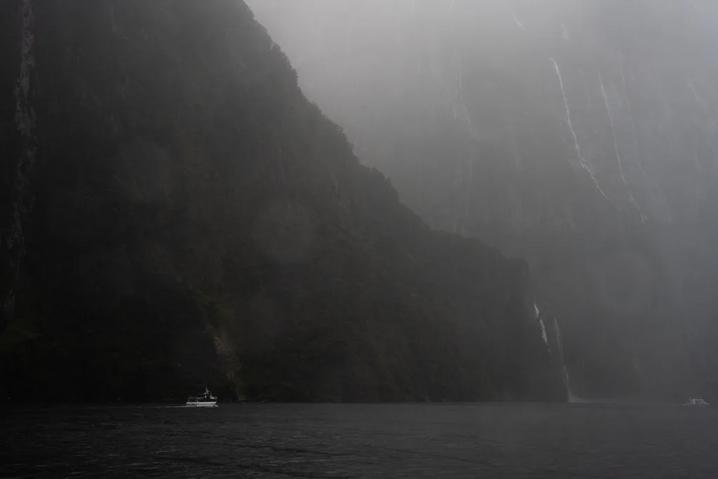 Bowen Falls plunging over moss-covered rocks into the emerald waters of Milford Sound