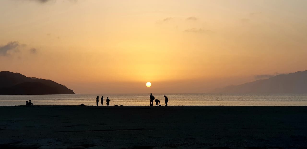 Colorful painted boats moored in Mindelo harbor with the volcanic hills of São Vicente rising in the background