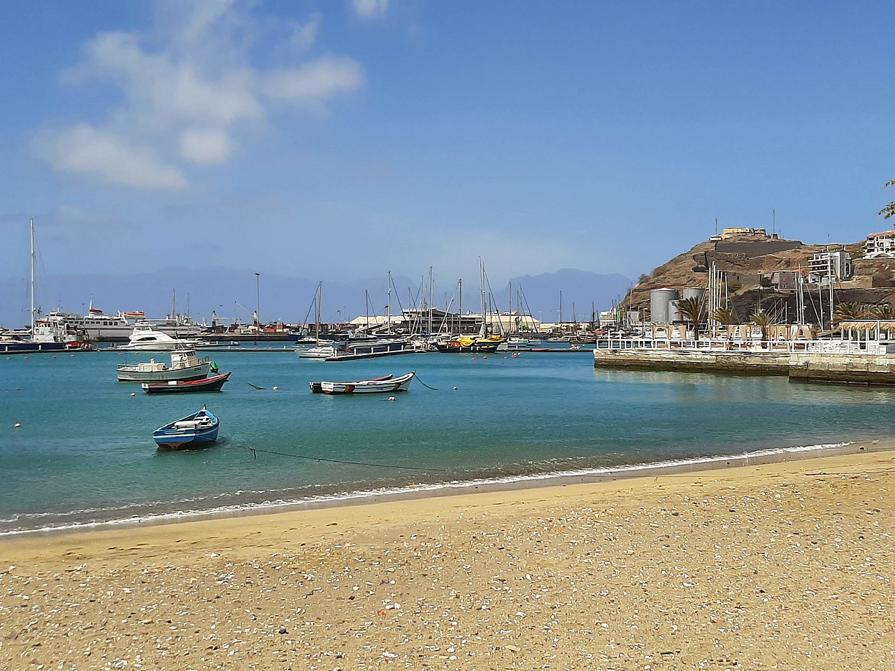 Mindelo harbor panorama showing Porto Grande bay with fishing boats and the volcanic hills of São Vicente rising behind the waterfront