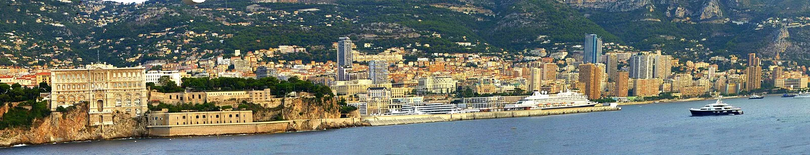 Monaco waterfront panorama from the sea showing the Rock, Oceanographic Museum, cruise port, and Monte Carlo skyline