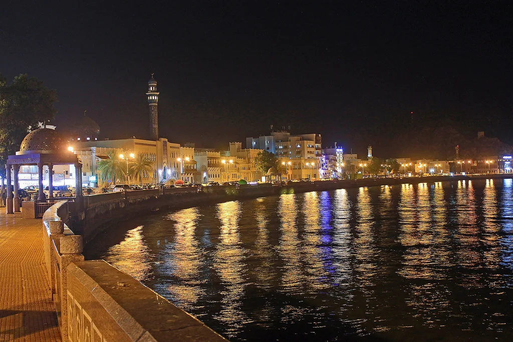 Quiet street in old Muscat with whitewashed buildings and traditional wooden doors