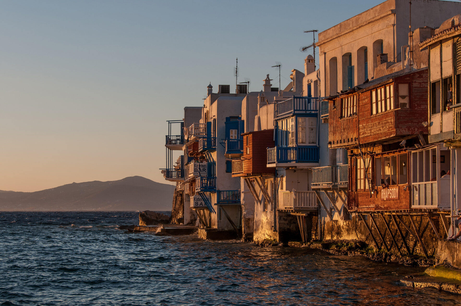 Little Venice waterfront at golden hour with colorful buildings overhanging the Aegean Sea
