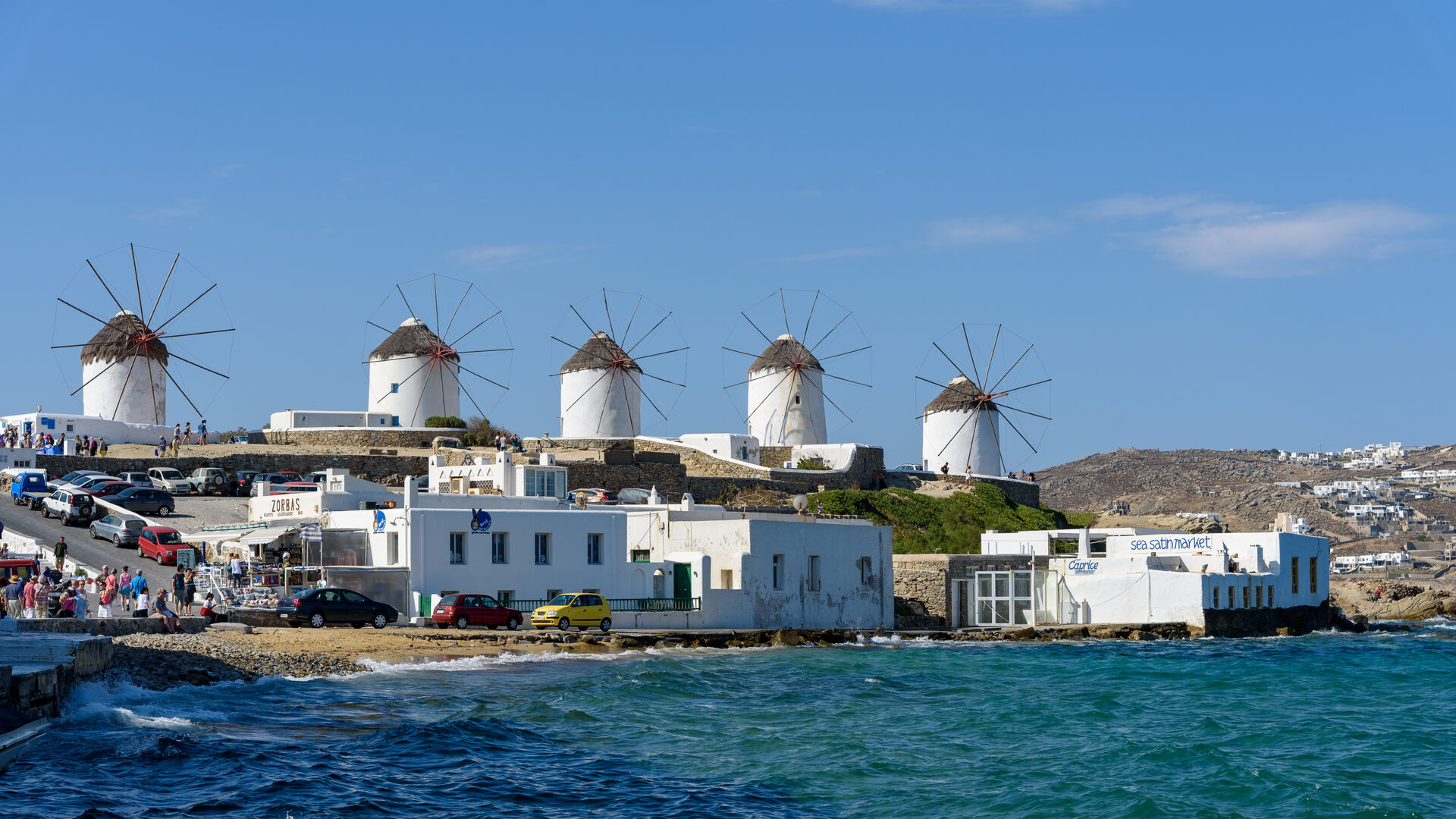 Famous Kato Mili windmills of Mykonos from the sea with turquoise water