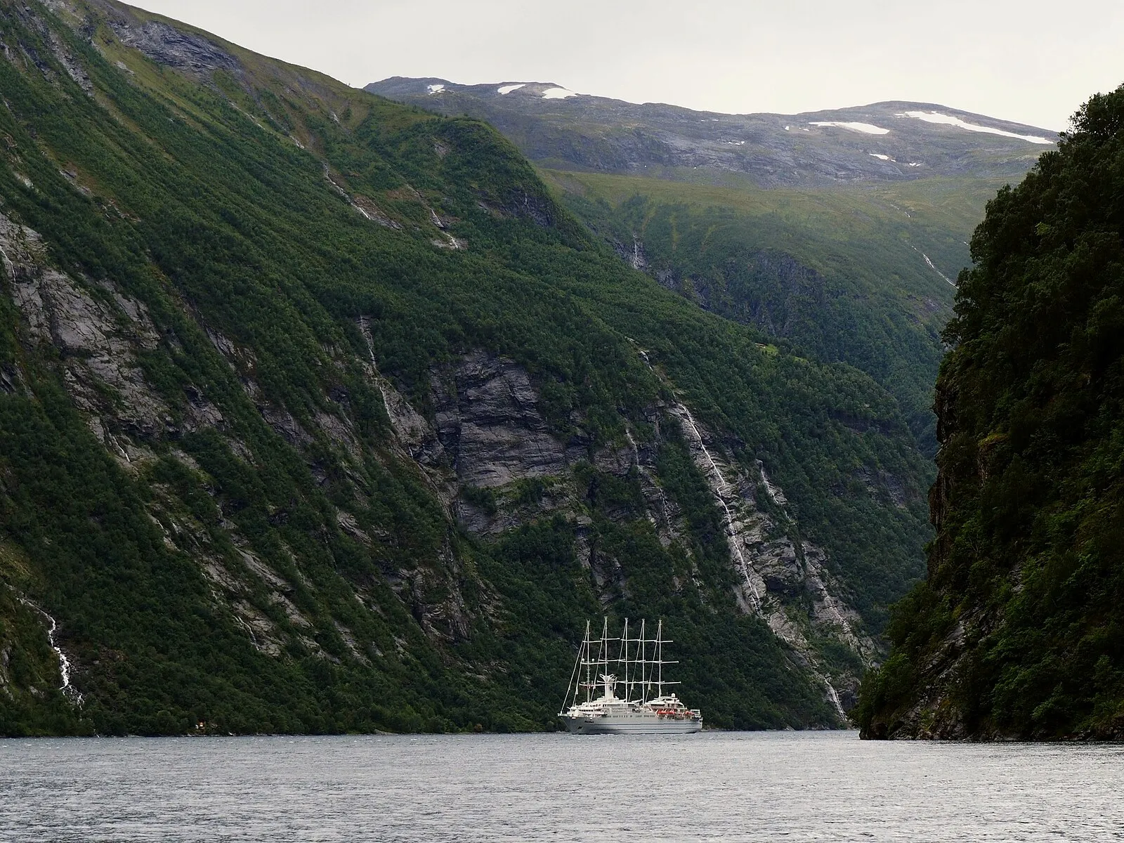 Trolltunga rock formation jutting out over a vast valley with a glacial lake far below