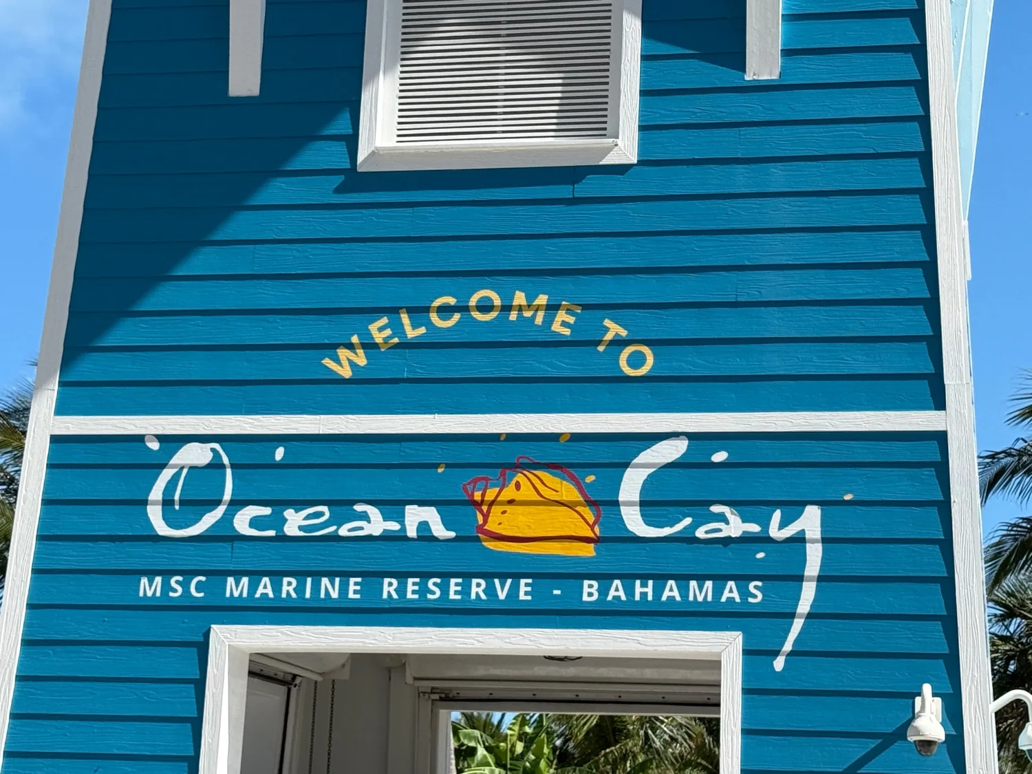 Painted teal-blue clapboard entrance reading Welcome to Ocean Cay MSC Marine Reserve Bahamas at the cruise pier