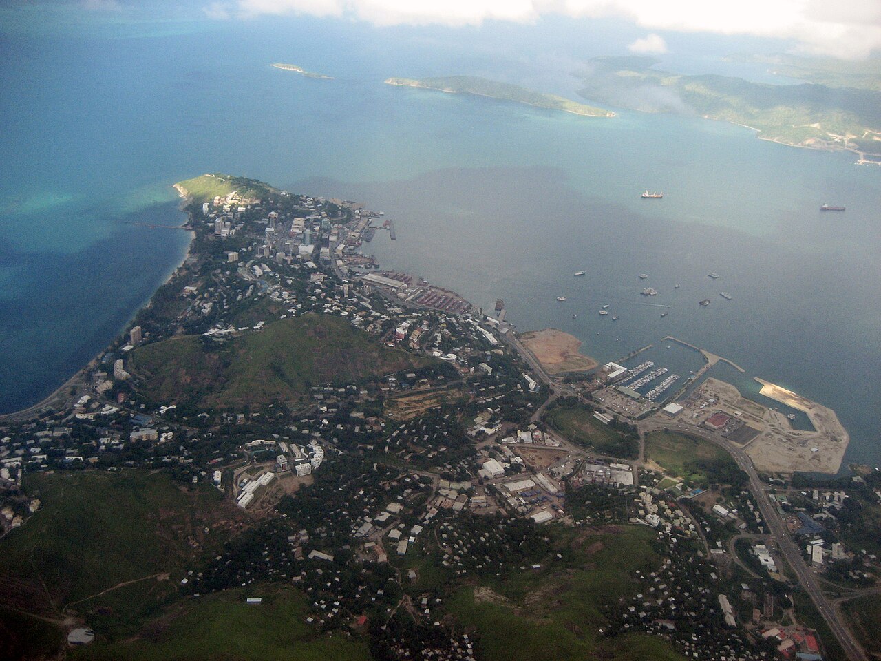 Port Moresby harbor with mountains in background and traditional boats on Coral Sea