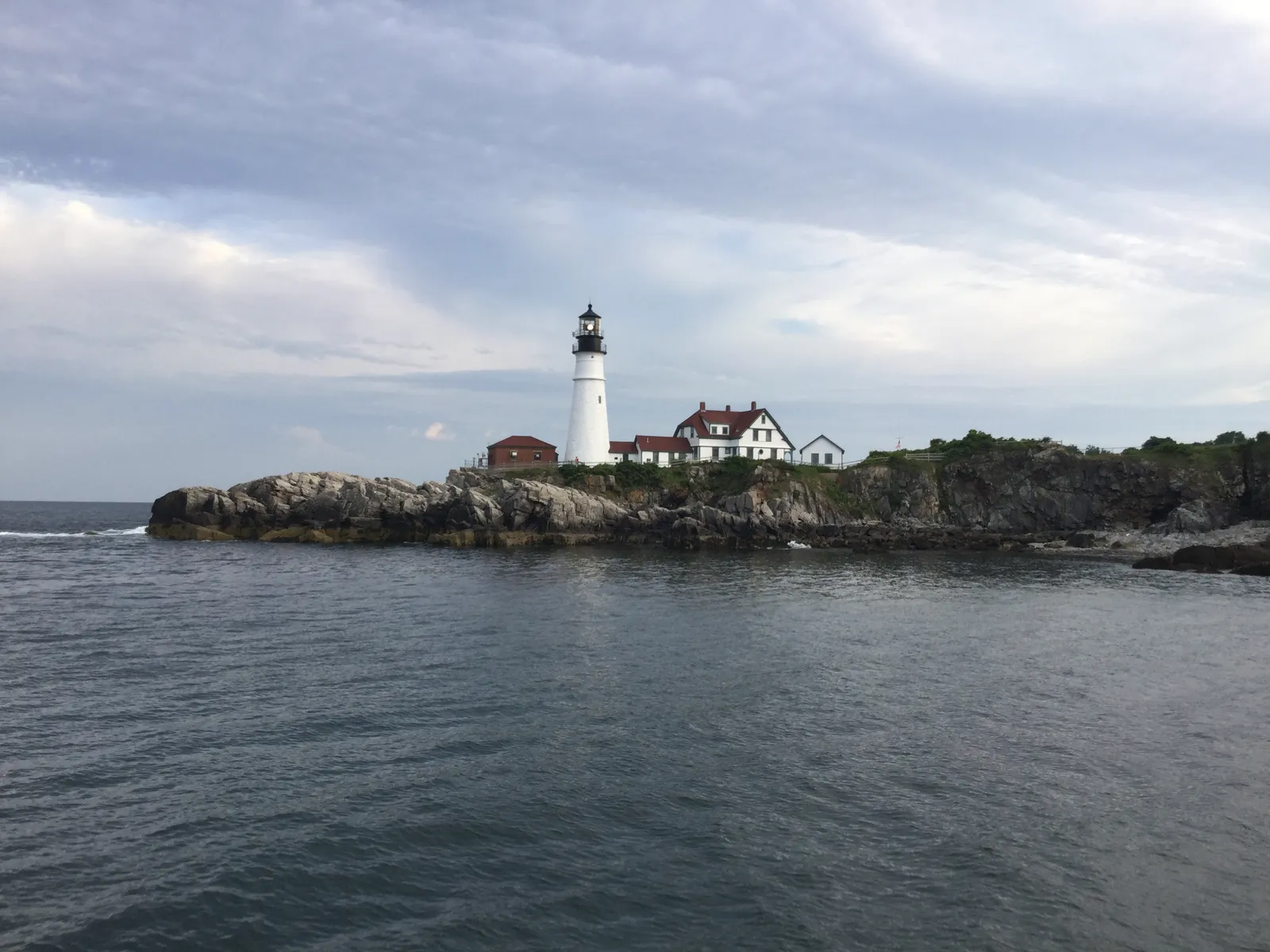 Fresh Maine lobster dinner served on a tray with drawn butter, corn, and coleslaw at a waterfront lobster shack