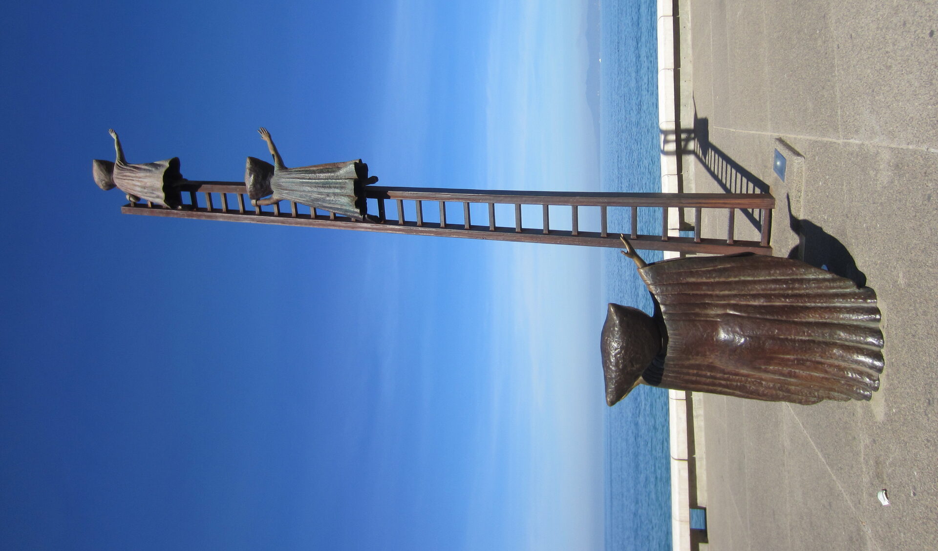 Bronze sculpture on Puerto Vallarta's Malecon boardwalk with Banderas Bay and mountains in the background