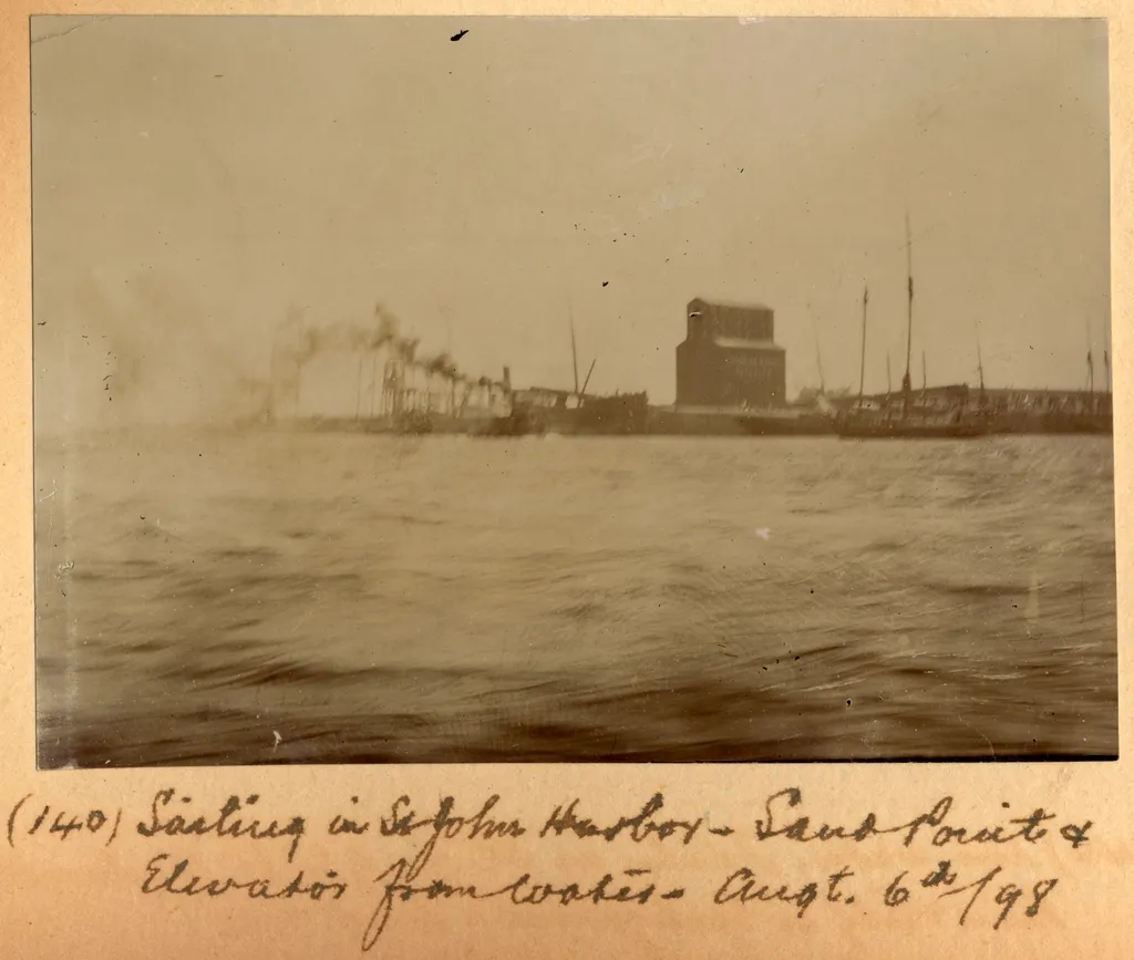 1898 sepia photograph of sailing in Saint John Harbour showing Sand Point and grain elevator