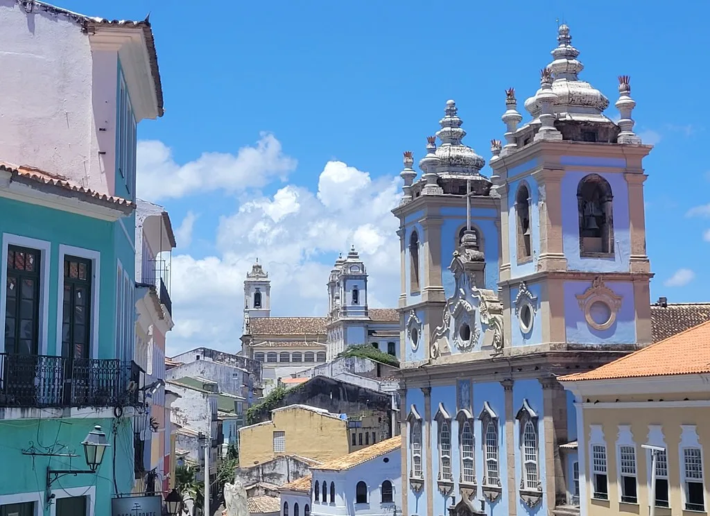 Interior of the Church of Sao Francisco in Salvador showing walls and ceiling entirely covered in ornate gold leaf carvings of angels, vines, and floral motifs
