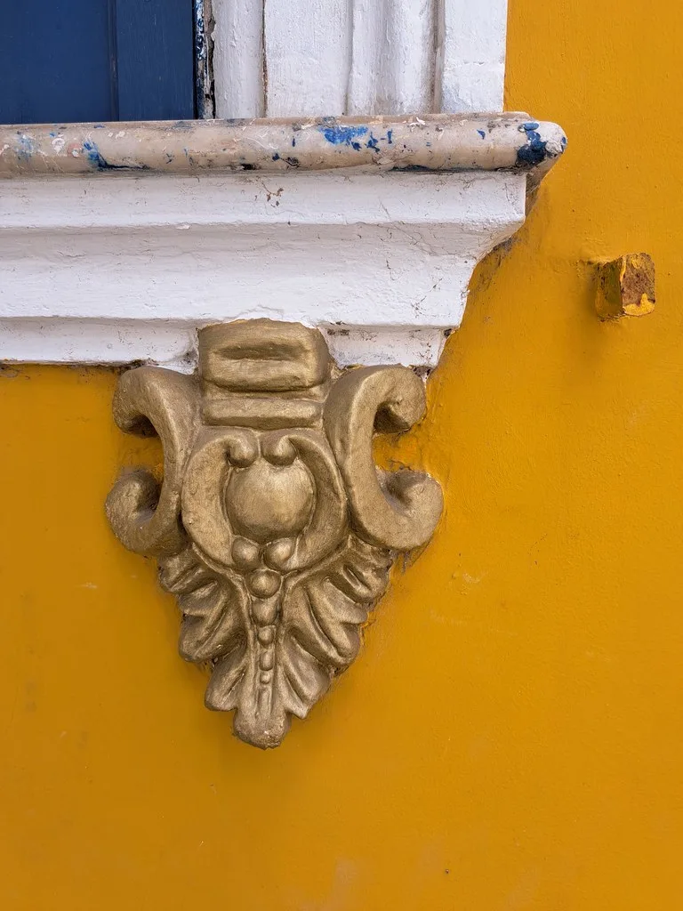 Narrow cobblestone street in Pelourinho lined with two- and three-story colonial buildings painted in vivid yellow, blue, and pink