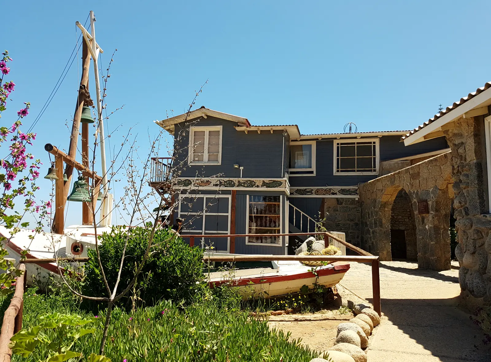 A wooden boat and the bell tower in the grounds of Pablo Neruda's house at Isla Negra