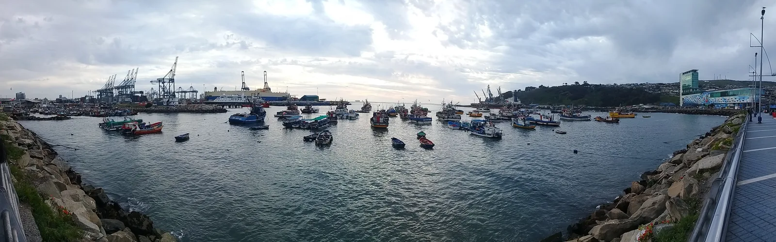 A wide view over the Port of San Antonio showing container stacks, gantry cranes and quays along the Chilean coast