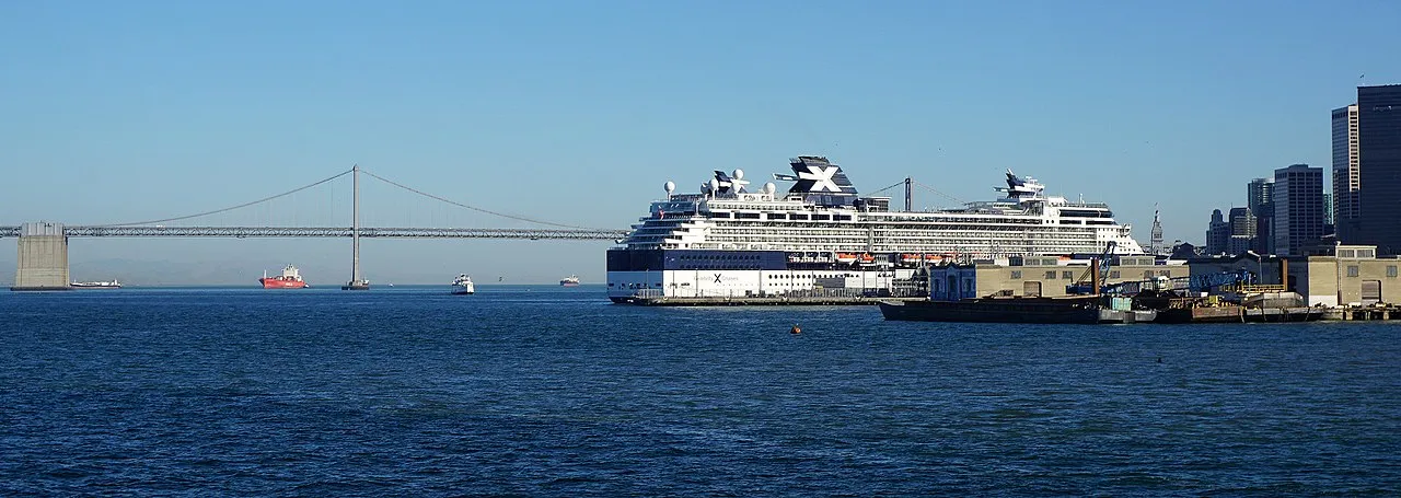 Celebrity cruise ship docked at San Francisco with Bay Bridge in the background