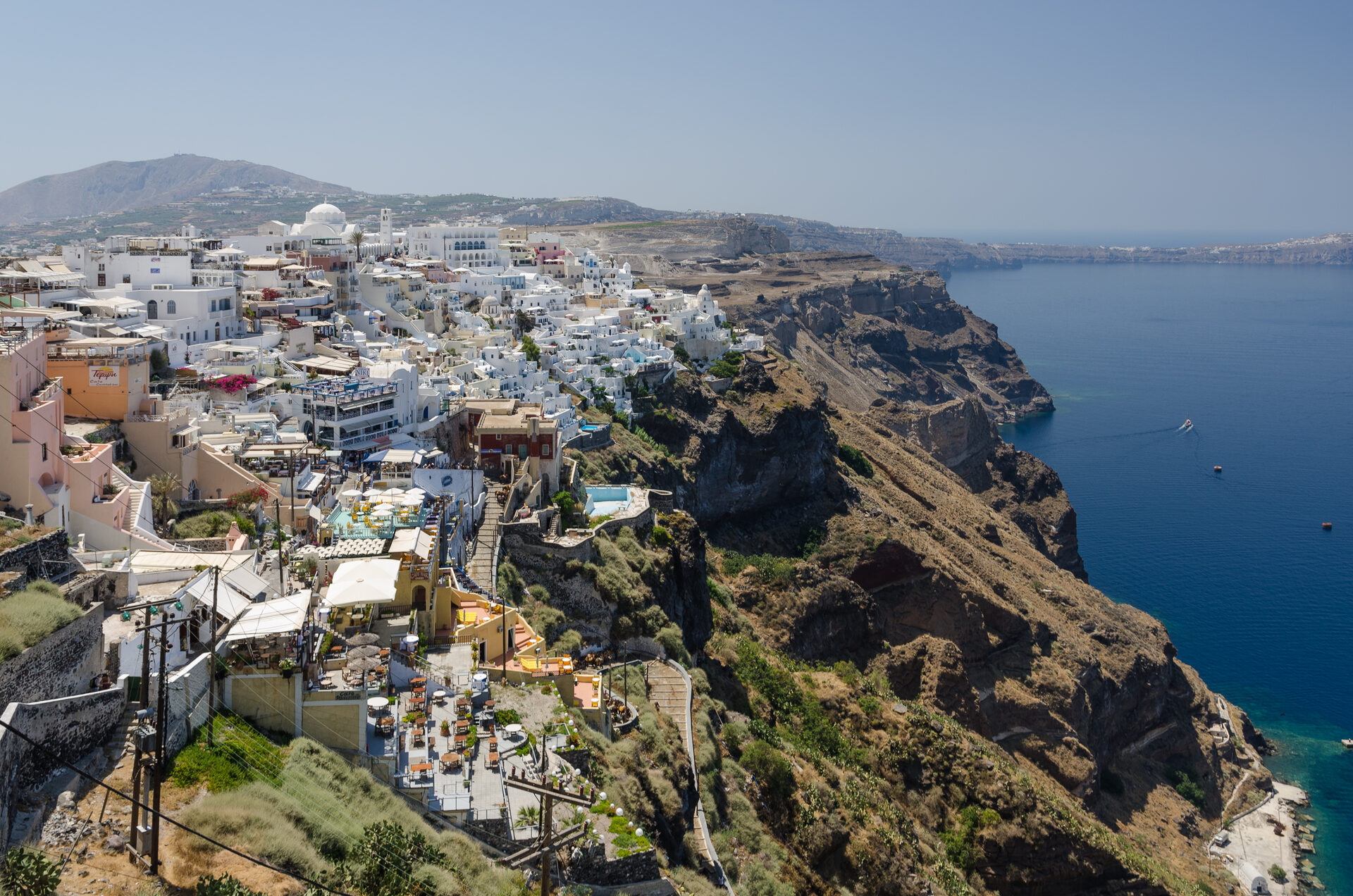 Fira town perched on the volcanic caldera cliffs with white buildings cascading toward the Aegean Sea
