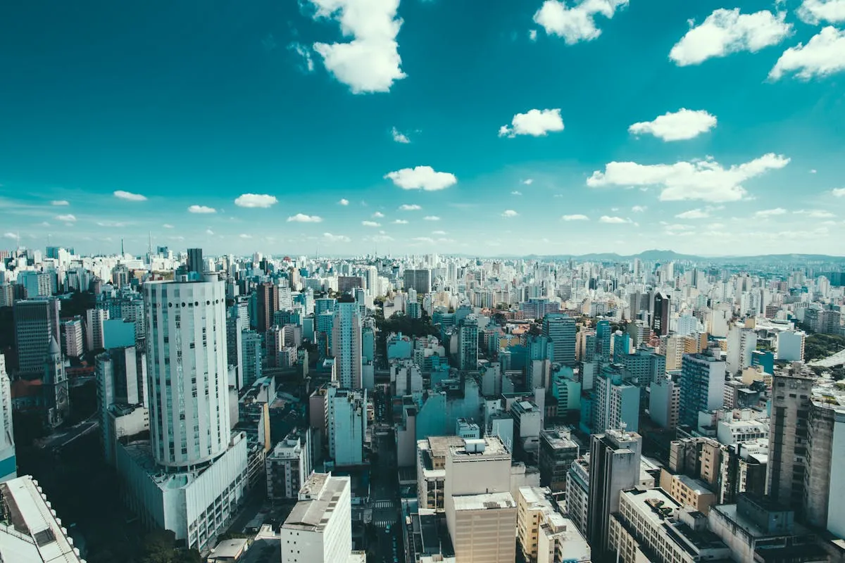 Panoramic view of a coastal bay with green mountains rising behind a city skyline