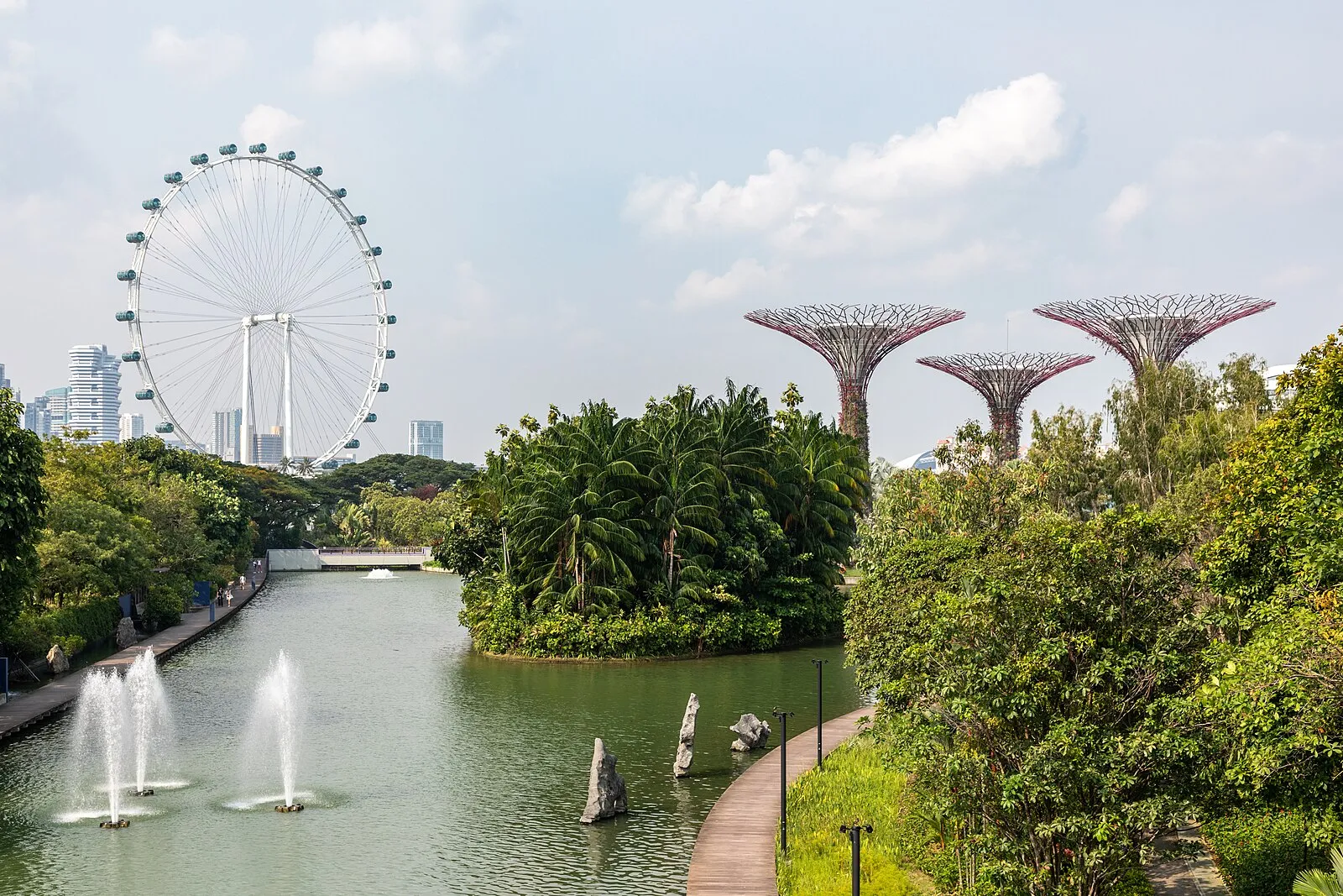 Gardens by the Bay with Supertree Grove and Singapore Flyer visible across a lotus pond