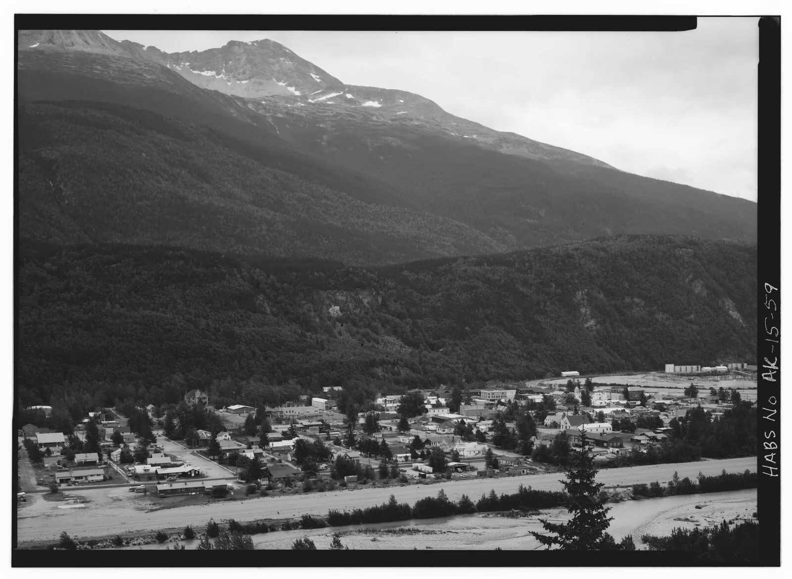 Historical HABS black and white aerial photo of Skagway town with Skagway River, mountains, and storage tanks