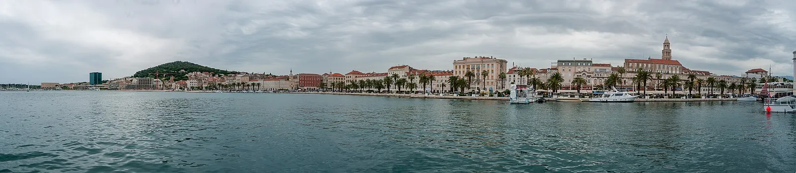 Split waterfront panorama from the harbor showing the Riva promenade, Diocletian's Palace bell tower, and palm trees