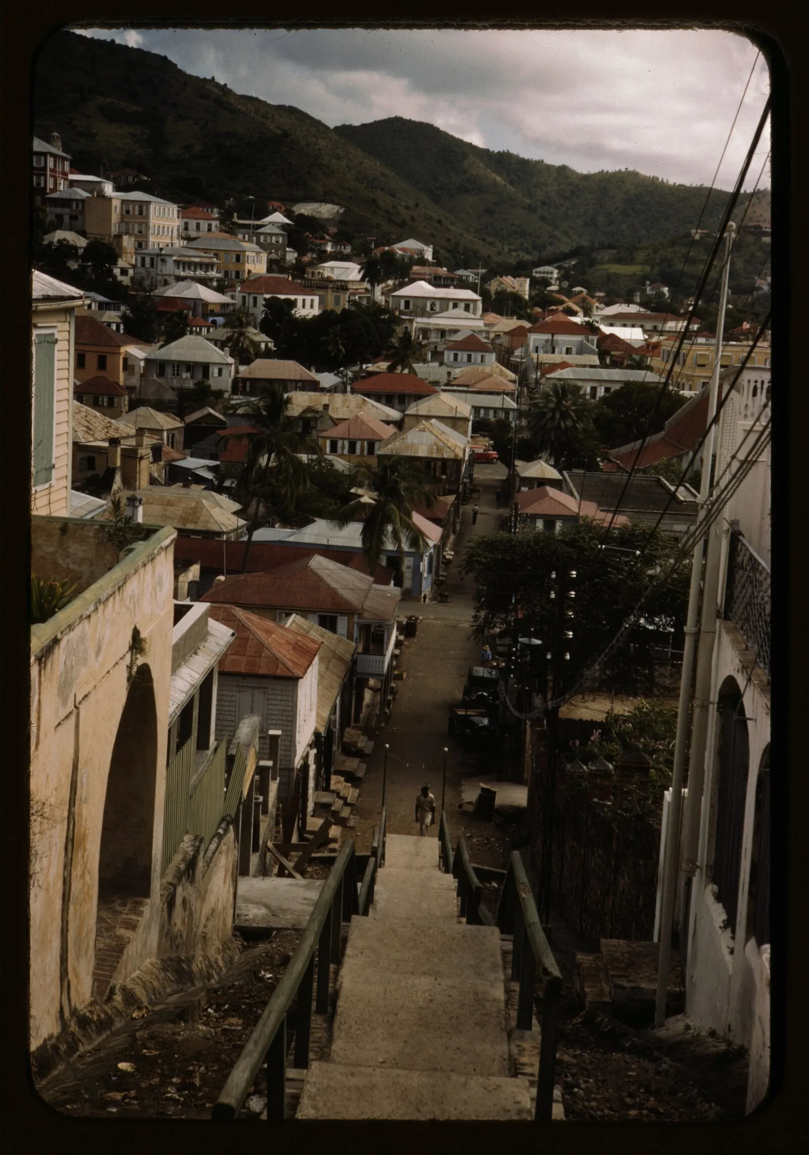 Vintage color photograph looking down steep stairs at Charlotte Amalie rooftops with red tin roofs