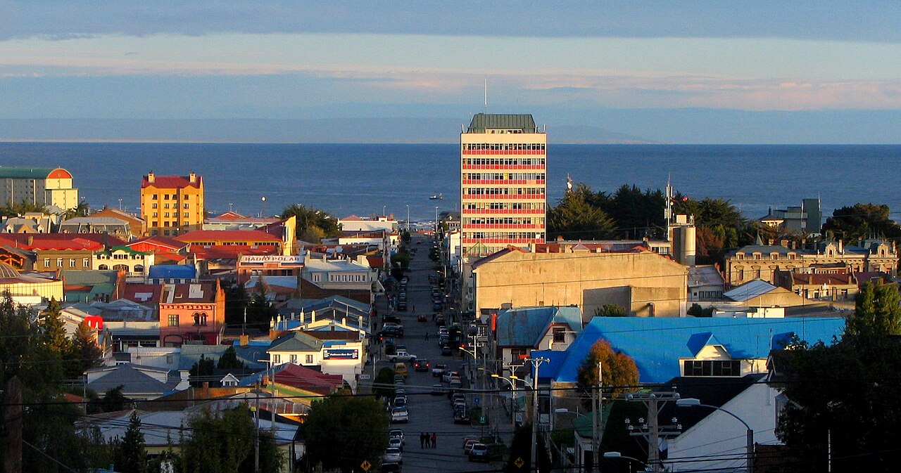 Punta Arenas downtown at golden hour with colorful buildings and Strait of Magellan beyond