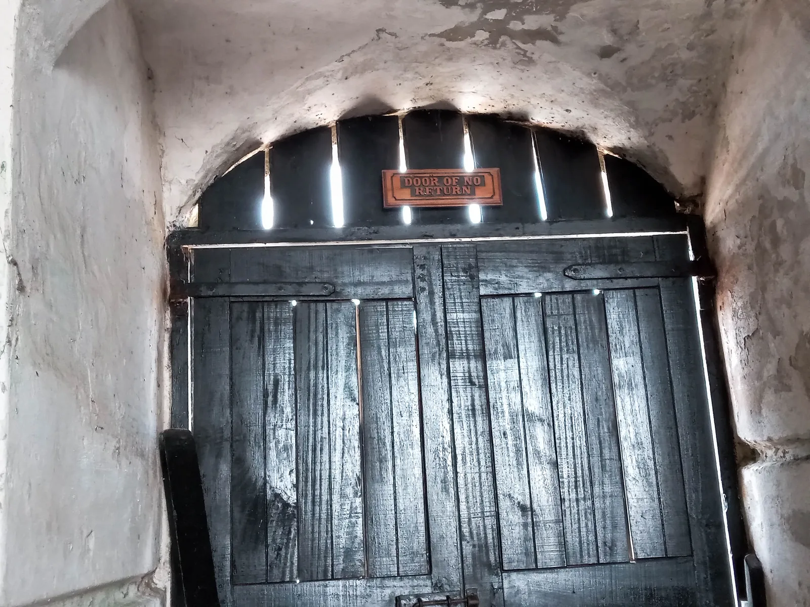 The Door of No Return at Cape Coast Castle, a low doorway at the end of a passage opening toward the sea